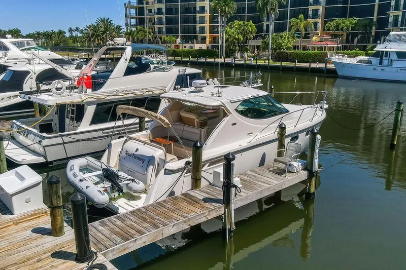 Slide: The Image of 2008 Tiara Yachts 3900 Sovran docked at marina, surrounded by other boats and waterfront buildings. - 3