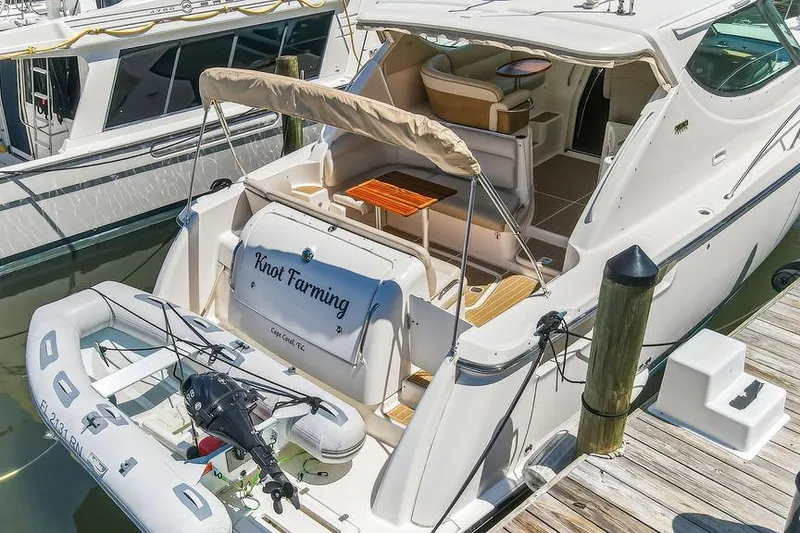 Slide: The Image of 2008 Tiara Yachts 3900 Sovran docked with inflatable boat, featuring spacious deck and seating. - 9