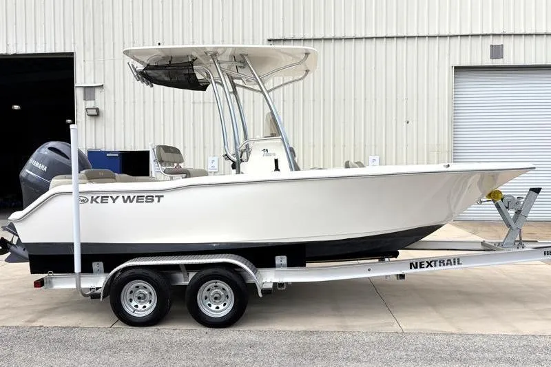 The Image of 2023 Key West 203 FS boat on trailer, parked outside a warehouse. - 0