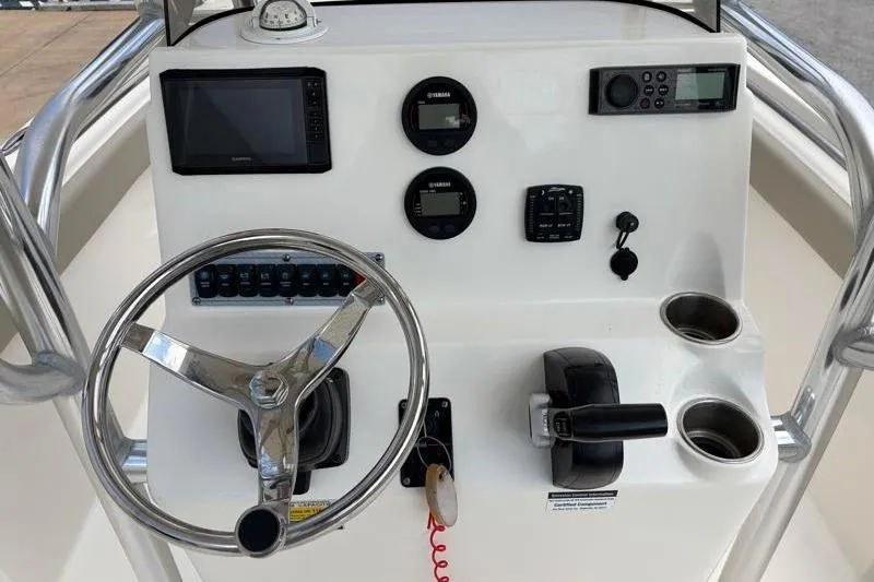 Slide: The Image of 2023 Key West 203 FS boat dashboard with steering wheel, gauges, and controls. - 25