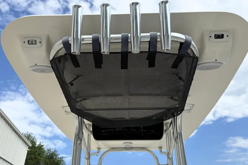 Slide: The Image of 2023 Key West 203 FS boat T-top with rod holders and storage net under blue sky. - 35