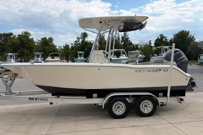 Slide: The Image of 2023 Key West 203 FS boat on trailer, parked outdoors under cloudy sky. - 4
