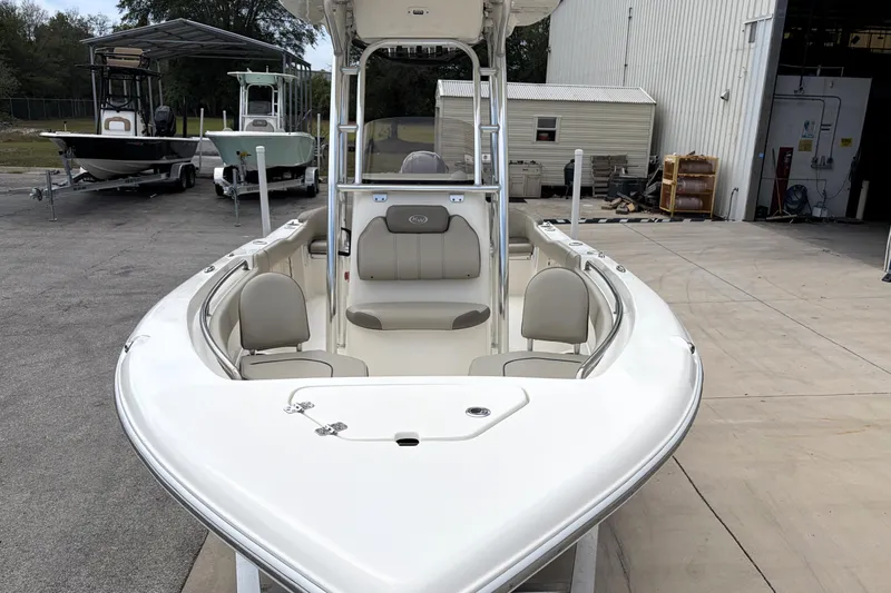 Slide: The Image of 2023 Key West 203 FS boat with seating, docked near a warehouse. - 6