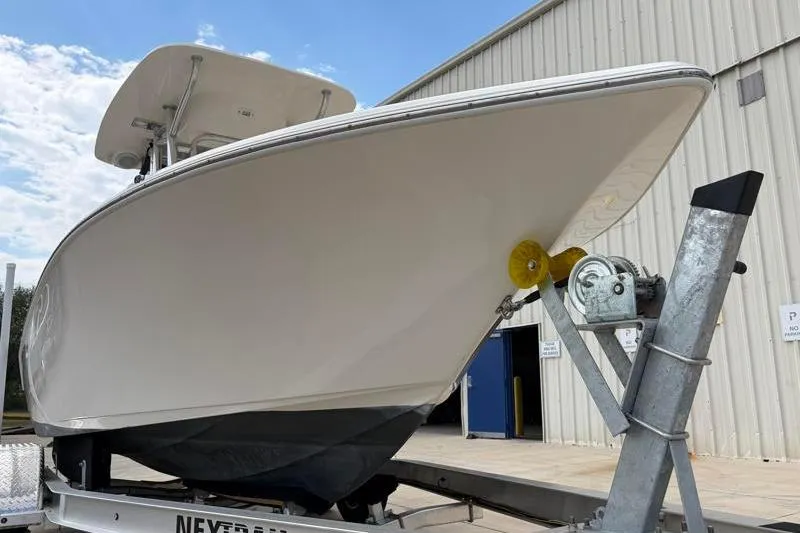 Slide: The Image of 2023 Key West 203 FS boat on trailer near industrial building. - 8