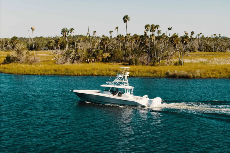 The Image of 2019 HCB 42 Siesta boat cruising on a scenic waterway with palm trees. - 0