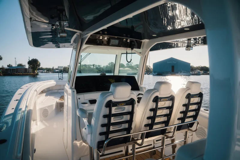 Slide: The Image of 2019 HCB 42 Siesta boat interior with helm seats and waterfront view. - 10