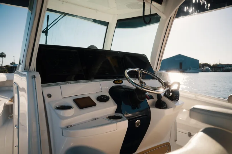 Slide: The Image of 2019 HCB 42 Siesta boat helm with steering wheel and navigation controls, dockside view. - 15