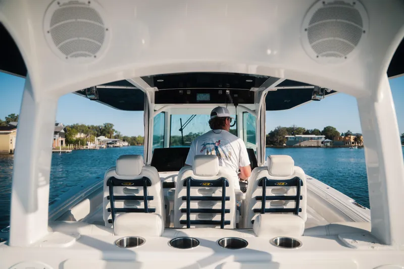 Slide: The Image of 2019 HCB 42 Siesta boat interior with captain navigating on a sunny day. - 19