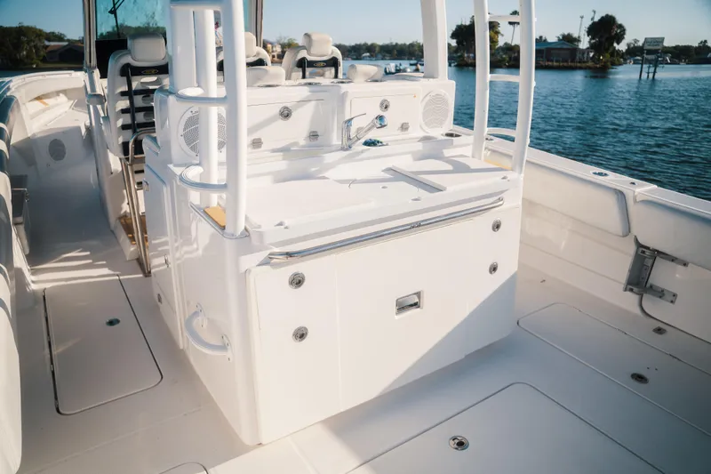 Slide: The Image of 2019 HCB 42 Siesta boat interior with seating and storage, docked by the water. - 26