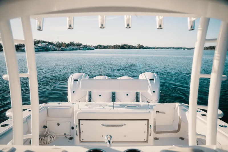 Slide: The Image of 2019 HCB 42 Siesta boat on calm water, showcasing triple outboard engines. - 29