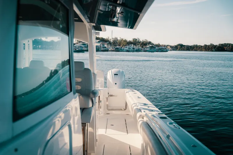 Slide: The Image of 2019 HCB 42 Siesta boat cruising on calm waters near a marina. - 3