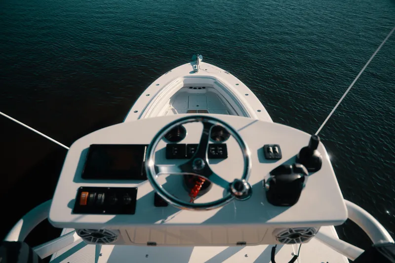 Slide: The Image of Helm view of 2019 HCB 42 Siesta boat on calm water. - 38