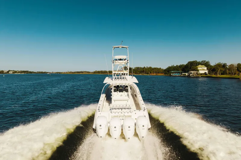 Slide: The Image of 2019 HCB 42 Siesta boat cruising on a calm lake under clear blue skies. - 49