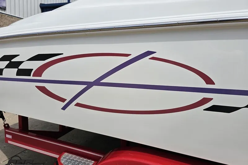 Slide: The Image of 1999 Baja 272 boat with colorful graphics and checkered pattern on the side. - 11