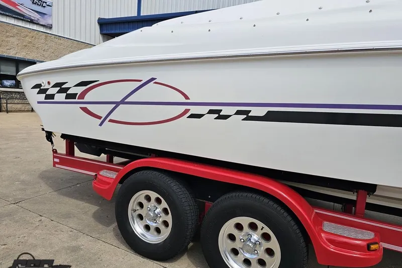 Slide: The Image of 1999 Baja 272 boat on red trailer with racing stripe design. - 12