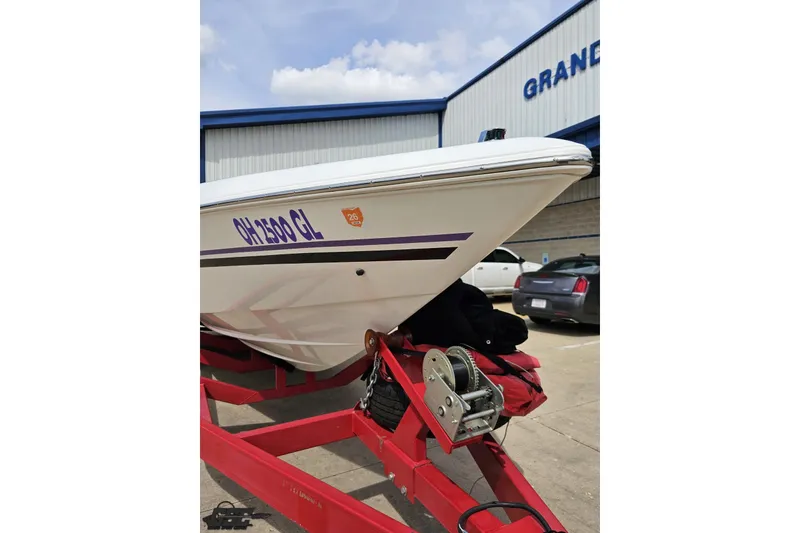 Slide: The Image of 1999 Baja 272 boat on red trailer, parked outside a building. - 15