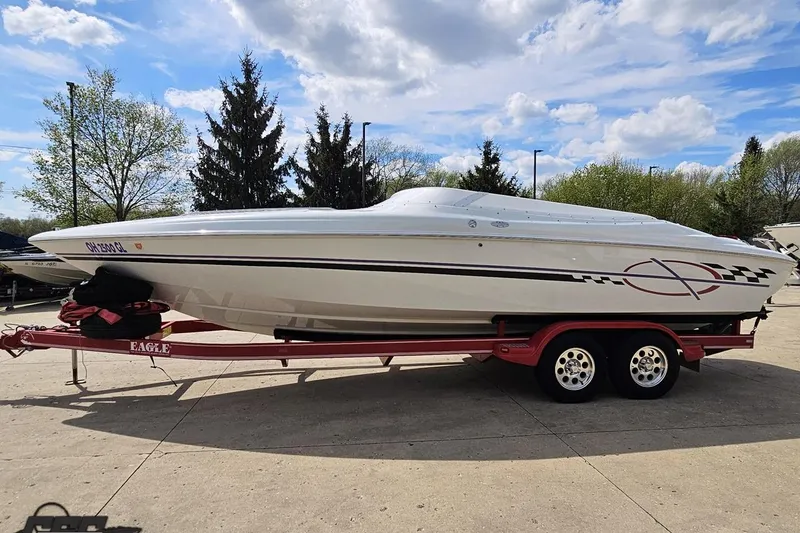 Slide: The Image of 1999 Baja 272 speedboat on a red trailer, parked outdoors under a cloudy sky. - 20