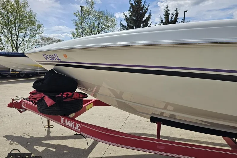 Slide: The Image of 1999 Baja 272 boat on red Eagle trailer, parked outdoors. - 23