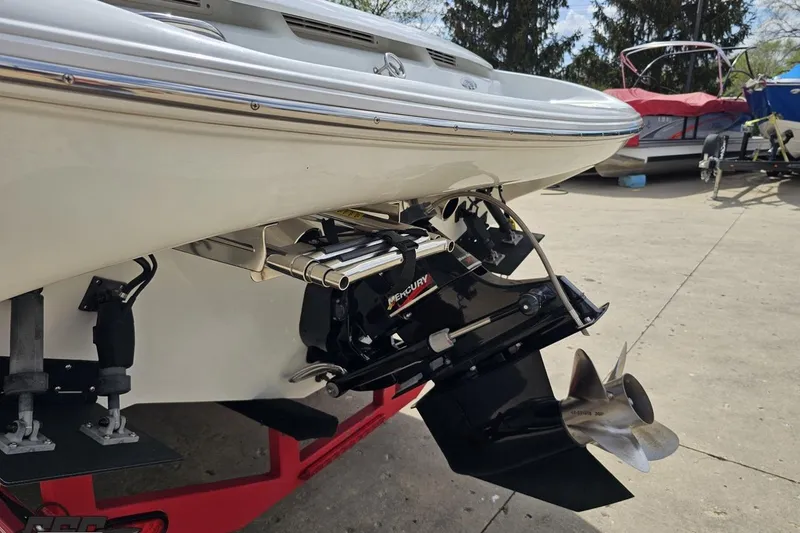 Slide: The Image of 1999 Baja 272 boat with Mercury outboard motor and propeller, parked on a trailer. - 30