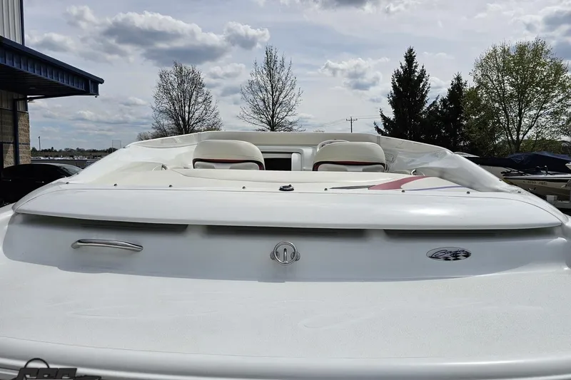 Slide: The Image of 1999 Baja 272 boat, rear view, white exterior, parked outdoors under cloudy sky. - 37