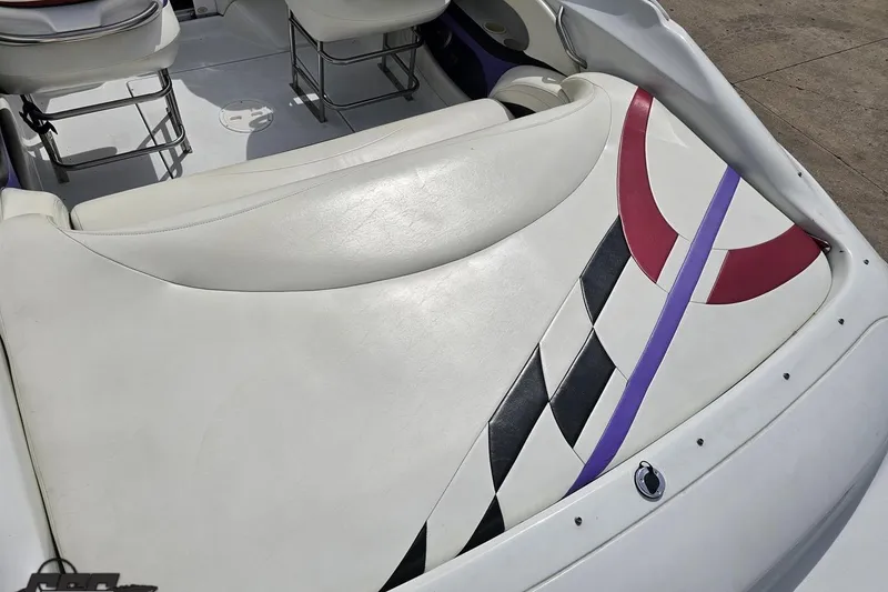 Slide: The Image of 1999 Baja 272 boat interior with white seats and colorful geometric design. - 40