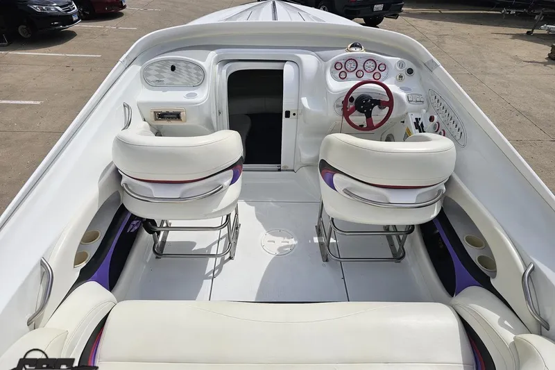 Slide: The Image of 1999 Baja 272 boat interior with white seating and red steering wheel. - 45