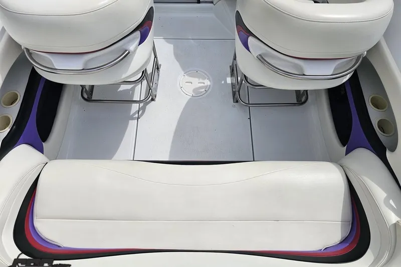 Slide: The Image of Interior of a 1999 Baja 272 boat with white and purple seating. - 46