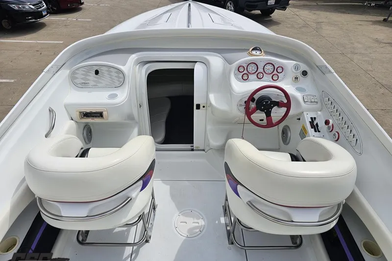 Slide: The Image of 1999 Baja 272 boat interior with white seating, red steering wheel, and dashboard controls. - 47