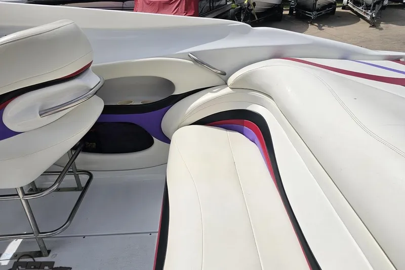Slide: The Image of Interior of a 1999 Baja 272 boat with white and purple seating. - 49