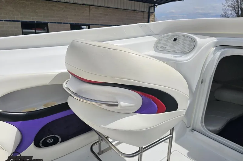 Slide: The Image of Interior of a 1999 Baja 272 boat featuring stylish white and purple seating. - 53
