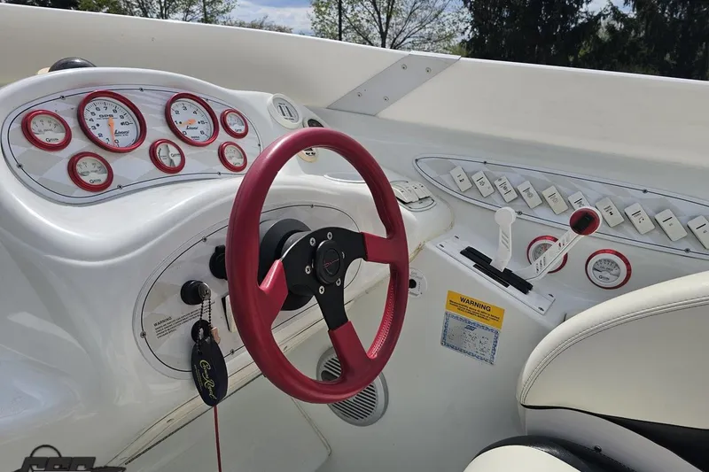 Slide: The Image of 1999 Baja 272 boat dashboard with red steering wheel and gauges. - 57