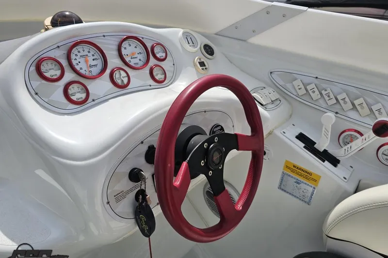 Slide: The Image of 1999 Baja 272 boat dashboard with red steering wheel and gauges. - 58