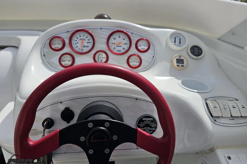 Slide: The Image of 1999 Baja 272 boat dashboard with red steering wheel and gauges. - 59