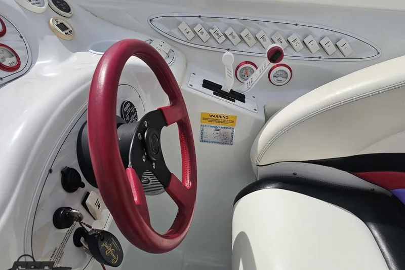 Slide: The Image of 1999 Baja 272 boat cockpit with red steering wheel and control panel. - 62