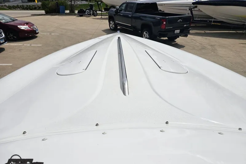 Slide: The Image of Bow view of a 1999 Baja 272 boat in a parking lot. - 65