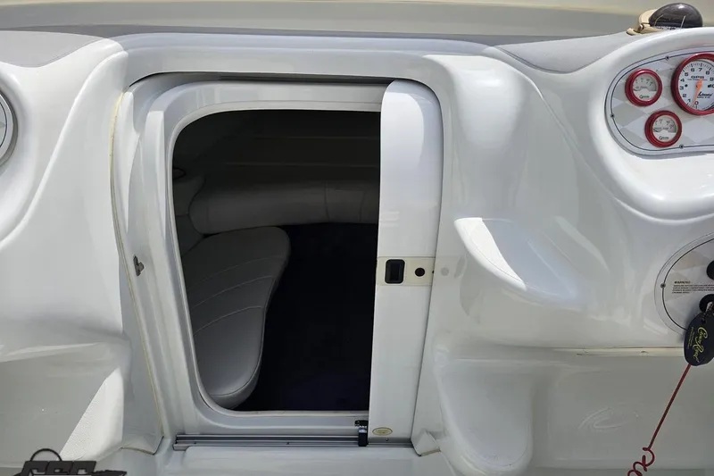 Slide: The Image of 1999 Baja 272 boat interior with open cabin door and dashboard gauges. - 66