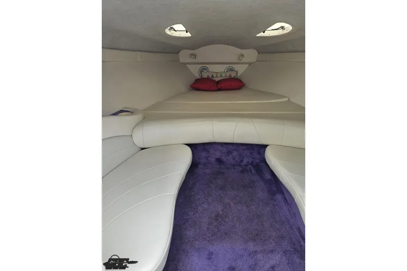 Slide: The Image of Interior of a 1999 Baja 272 boat with white seating and purple carpet. - 67