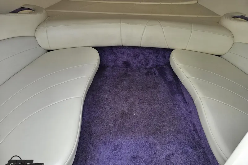 Slide: The Image of Interior of a 1999 Baja 272 boat with white seating and purple carpet. - 68