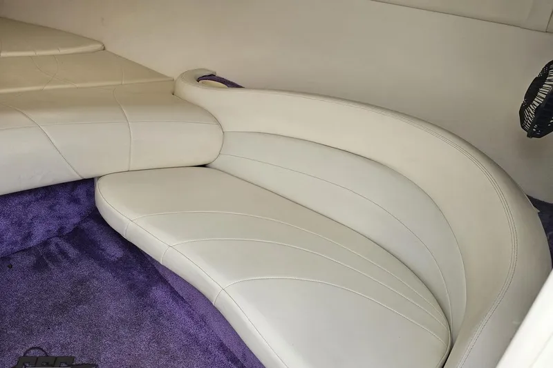 Slide: The Image of Interior of a 1999 Baja 272 boat with white leather seating and purple carpet. - 69