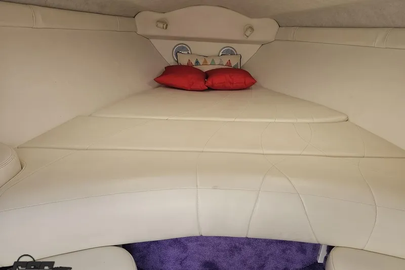 Slide: The Image of Interior cabin of a 1999 Baja 272 boat with white seating and red pillows. - 71