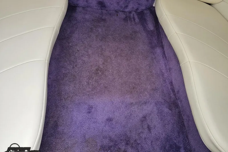 Slide: The Image of Purple carpet and white seats in a 1999 Baja 272 boat interior. - 72