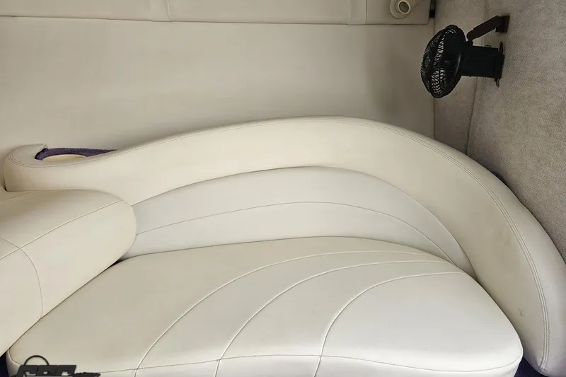 Slide: The Image of 1999 Baja 272 boat interior with white leather seating and a small fan. - 73