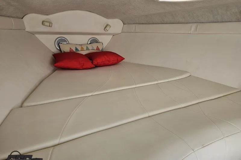 Slide: The Image of Interior cabin of a 1999 Baja 272 boat with red pillows and beige upholstery. - 74