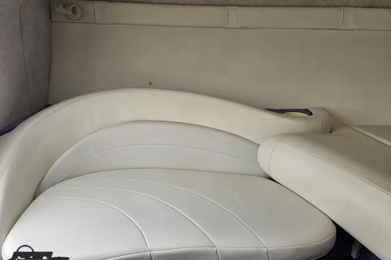 Slide: The Image of Interior seating of a 1999 Baja 272 boat, featuring white leather upholstery. - 76