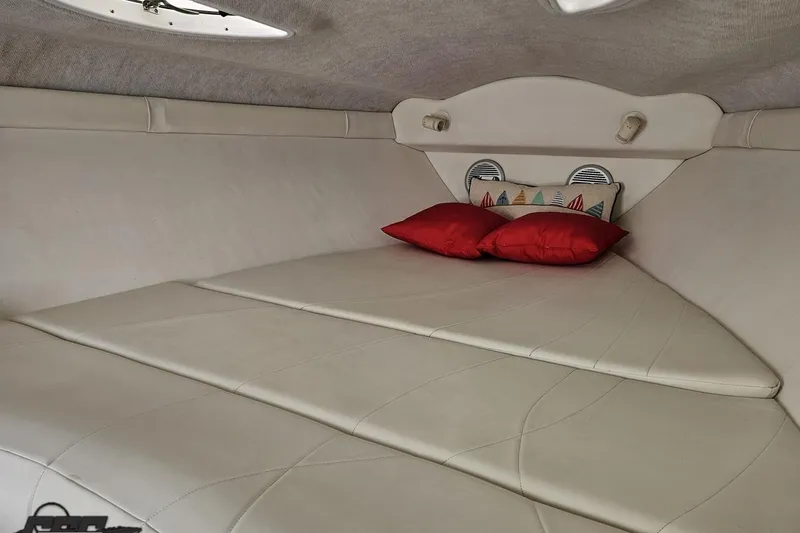 Slide: The Image of Interior cabin of a 1999 Baja 272 boat with red pillows and nautical decor. - 77