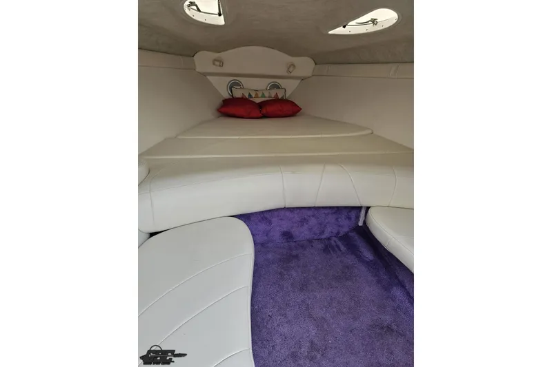 Slide: The Image of Interior cabin of a 1999 Baja 272 boat with white seating and purple carpet. - 78