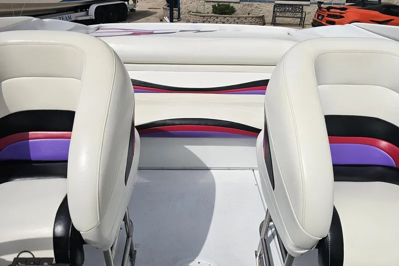 Slide: The Image of Interior of a 1999 Baja 272 boat with white, black, red, and purple seating. - 80