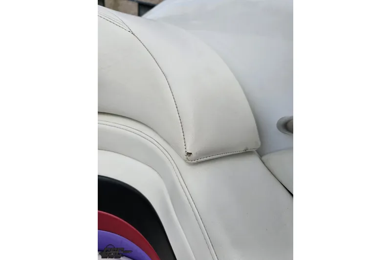 Slide: The Image of White leather seat detail of a 1999 Baja 272 boat. - 84