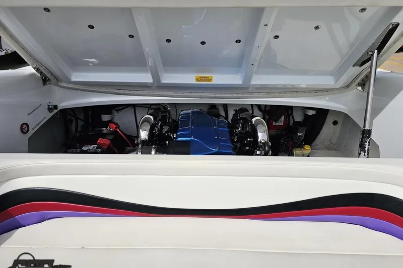 Slide: The Image of Engine compartment of a 1999 Baja 272 boat with open hatch and visible components. - 90