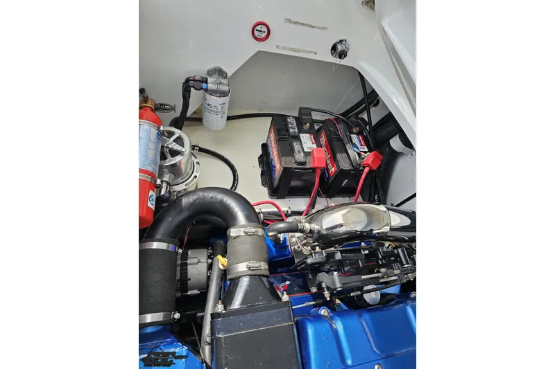 Slide: The Image of Engine compartment of a 1999 Baja 272 boat, featuring battery and mechanical components. - 97